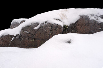 Poster - natural stone in snow isolated on black background
