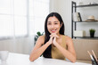 Beautiful asian woman chatting video conference online looking at camera sitting in living room at home. Business Woman looking at screen Meeting on social media. Work from home.