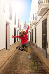 happy woman travel in Andalusia jumping in the street