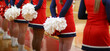 Horizontl picture of cheerleaderes with their pom poms behind their backs