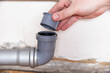 Installing a plug in the drain hole of the sewer from an unpleasant odor, close-up. Bad smell from the sewer