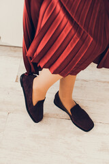 Wall Mural - Photo of women's legs in a stylish suede burgundy loafers. Woman wearing red skirt.