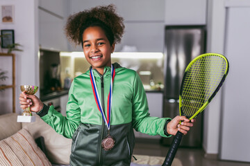 Excited girl with medals and trophy cup