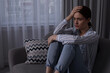 © New Africa - Unhappy young woman on sofa at home, space for text. Loneliness concept