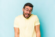 © Asier - Young caucasian man isolated on blue background laughs and closes eyes, feels relaxed and happy.