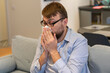 © Елена Бабанова - Close-up of a man using paper napkins while having a cold at home alone in an apartment