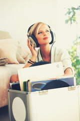 Wall Mural - Find your freedom in the music. A beautiful young woman listening to music while relaxing at home.