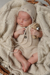 Canvas Print - Adorable newborn baby with toy bear sleeping in wicker basket, top view