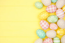 Easter Side Border With Modern Farmhouse Cloth And Pastel Eggs Over A Yellow Wood Banner Background. Above View With Copy Space.
