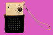 Vintage 1960's style AM transistor radio with hand strap on a pink background
