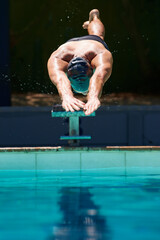 Starting the race. A young man diving off a starting block.