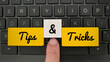 Tips and Trick text on color wooden blocks with laptop background.