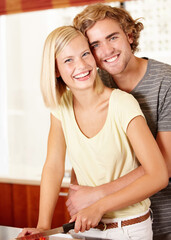 Wall Mural - Love in the kitchen. Portrait of a young couple standing in the kitchen.