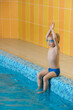 © ninelutsk - Toddler child learning to dive in indoor swimming pool with teacher. Standing on side, balancing and general physical activity for kids in water, early development. Boy kid instructed