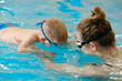 © ninelutsk - Toddler child learning to dive in indoor swimming pool with teacher. Standing on side, balancing and general physical activity for kids in water, early development. Boy kid instructed
