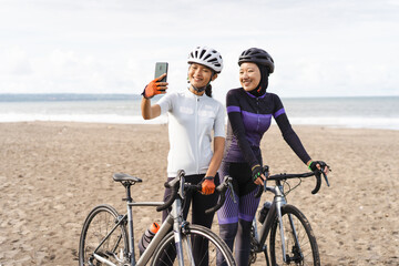 muslim woman cyclist taking selfie photo together at the beach