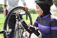Asian Muslim Bike Cyclist Pump Her Flat Tire Using Electric Pump