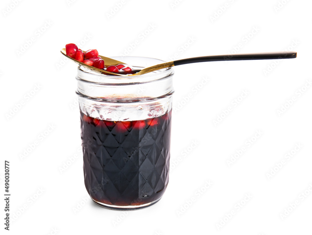 Jar of pomegranate molasses on white background