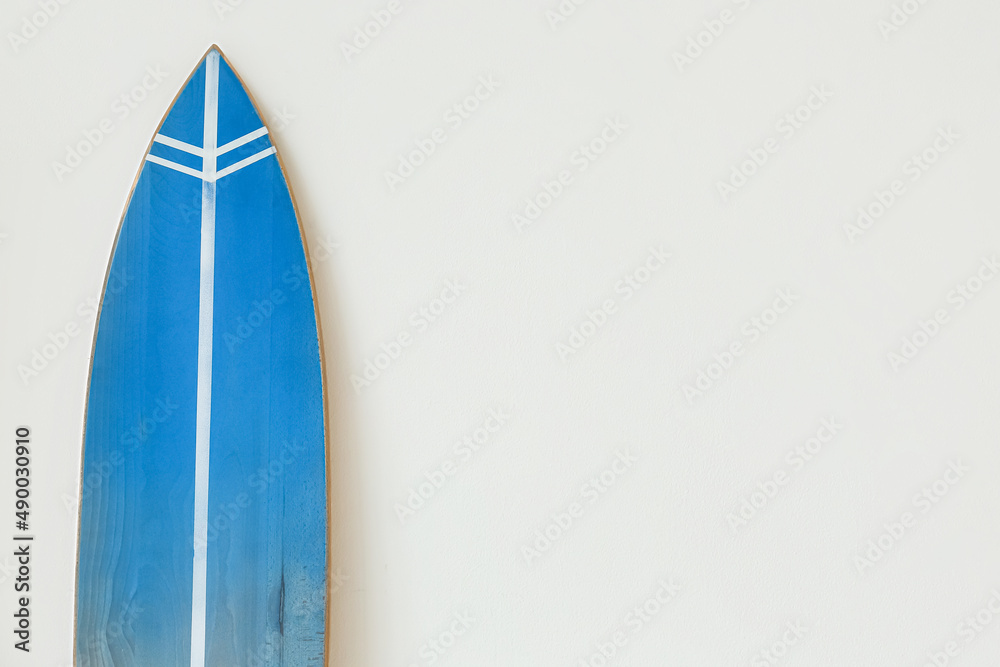 Blue surfboard near light wall