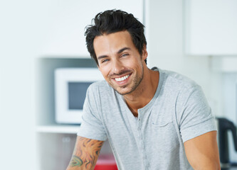 Wall Mural - Hes happy in his bachelor flat. Cropped portrait of a handsome young man in his kitchen.