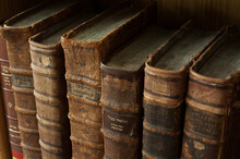 Dusty, Worn And Faded Leather-bound Jewish Holy Books Stacked Upright On A Library Shelf.
