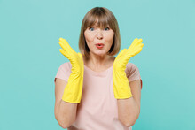 Elderly Cheerful Shocked Housewife Woman 50s In Pink T-shirt Yellow Rubber Gloves Doing Housework Spread Hands Isolated On Plain Pastel Light Blue Background Housekeeping Cleaning Tidying Up Concept.