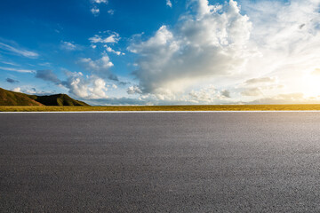 Empty asphalt road platform and beautiful blue sky with white clouds at sunrise