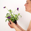 Mujer mirando planta con flor lila