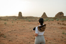 Traveling Woman Standing In Desert Terrain