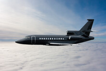 Black Modern Luxury Executive Business Jet Flies In The Air Above The Clouds
