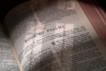The Bible Opened To The Book Of Psalms Lit Through A Church Window