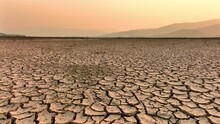 Drought And Climate Change, Landscape Of Cracked Earth With Orange Sky After Lake Drying On Summer. Water Crisis An Impact Of Global Warming.