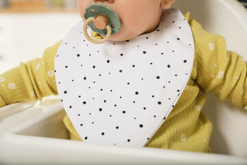 Sticker - Cute little baby wearing bib in highchair, closeup