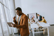 © BGStock72 - Young African American business man working with digital tablet and receiving great news in front of his coworkers at boardroom