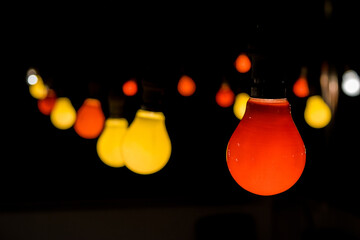 Poster - A festoon with red and yellow light bulbs lit up during a party celebration to create festive mood