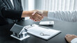 © Ngampol - Finishing to successful deal of real estate, Broker and client shaking hands after signing contract approved application form, concerning mortgage loan offer for and house insurance