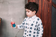 Little curly boy drinking boxed juice with a straw
