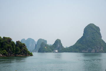 Wall Mural - Scenic view of the emerald water and cliffs covered in green forests of the Ha Long Bay, Vietnam