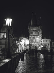 Wall Mural - Vertical grayscale shot of people on the Charles Bridge at night in Prague, Czech Republic