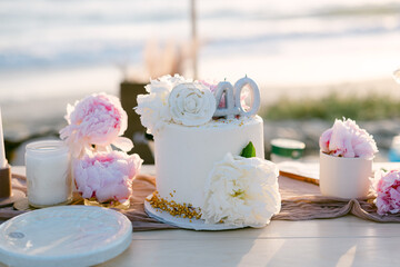 Wall Mural - Shallow focus of a 40th birthday white cake on California beach on a sunny day