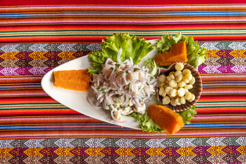 Sticker - Closeup shot of Mexican ceviche on a triangular plate with a colorful tablecloth surface