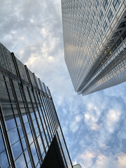 Wall Mural - Low angle shot of glass skyscrapers under the cloudy skies