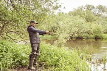 Wall Mural - Fisherman on the river bank.