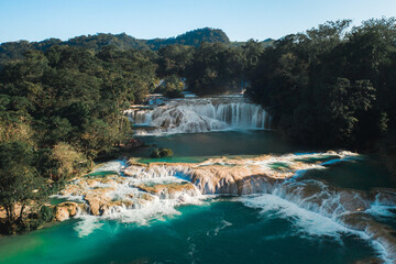 Sticker - Scenic view of a beautiful waterfall in the forest surrounded by lush nature