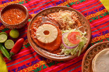 Wall Mural - Closeup shot of traditional food with meat and vegetables served on a clay plate with tortillas