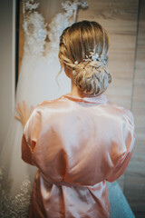 Wall Mural - Back shot of a bride standing in front of wedding dress