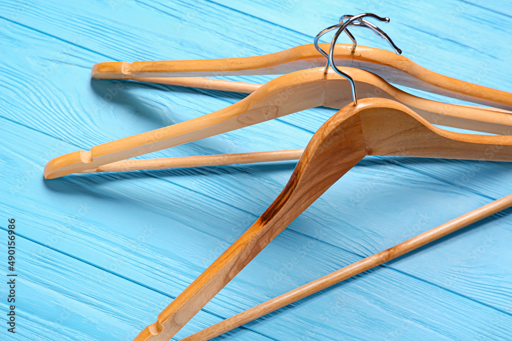 Clothes hangers on color wooden background