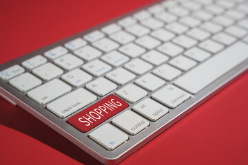 Canvas Print - Closeup shot of shopping text on a computer keyboard isolated on red background