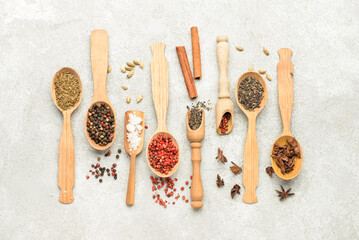 Wall Mural - Spoons with aromatic spices on light background