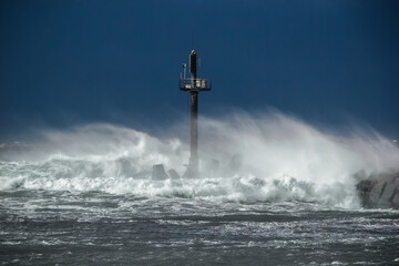 Canvas Print - Heavy storm at the gates to the port of Klaipeda, Lithuania. Baltic Sea against a gray cloudy sky